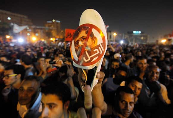 An Egyptian protester raises a shoe with a picture of Egyptian President Mohammed Morsi with Arabic that reads: