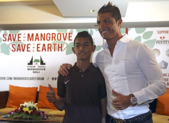 Cristiano Ronaldo poses with a fan named Martunis during a press conference in Kuta, Bali, Indonesia. Martunis was an Aceh tsunami survivor, who was reportedly found floating in the sea wearing a Portugal national soccer team`s jersey.