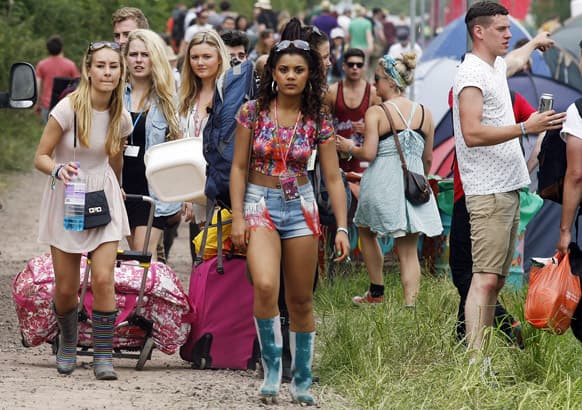 Festival goers arrive at the Glastonbury Music Festival site, Glastonbury, England. Thousands are to arrive for the three day festival that starts on Friday, June 28 with headliners, Arctic Monkeys, the Rolling Stones and Mumford and Sons.