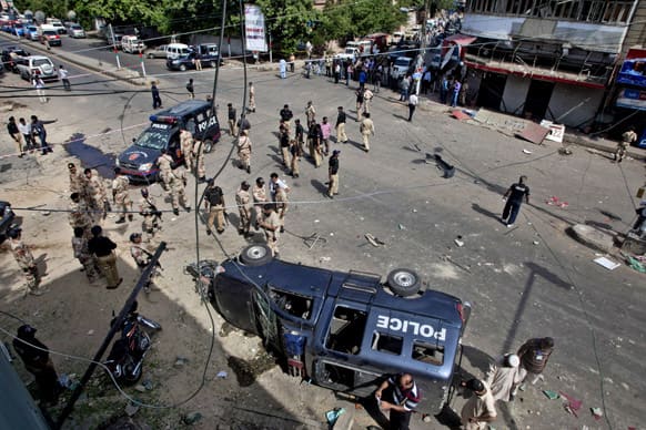 Pakistani security men gather at the site of a bomb blast in Karachi. A bomb targeting a senior judge in the southern Pakistani city of Karachi wounded him and killed several security personnel.