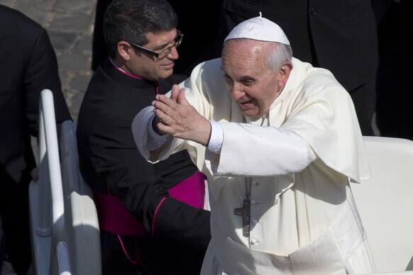 Pope Francis gestures as he arrives in St.Peter`s Square at the Vatican for his weekly general audience.