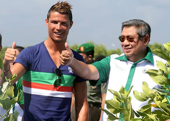 Indonesian President Susilo Bambang Yudhoyono, right, and soccer star Cristiano Ronaldo gesture for photographers during a tree-planting event in a mangrove forest at Tanjung Benoa bay, Bali, Indonesia.