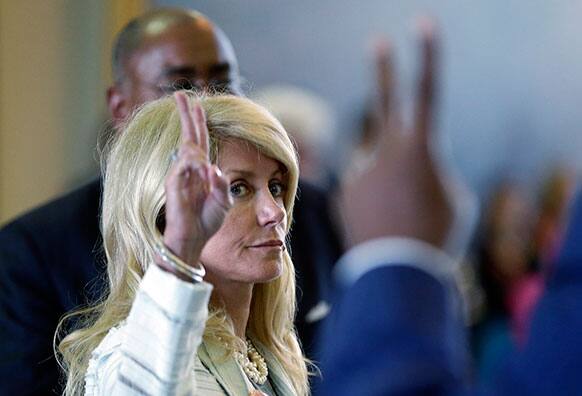 Sen. Wendy Davis, D-Fort Worth, left, votes against a motion to call for a rules violation during her filibusters of an abortion bill in Austin, Texas.