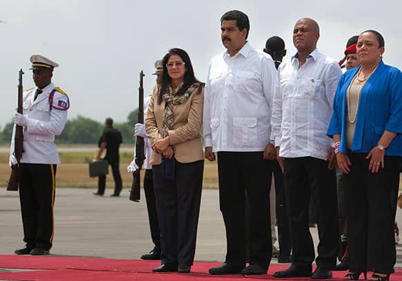 Venezuela`s First Lady Cilia Flores, left, Venezuela`s President Nicolas Maduro, second from left, Haiti`s President Michel Martelly, second from right, and Haiti`s First Lady Sophia Martelly listen to Haiti`s national anthem at Toussaint Louverture airport in Port-au-Prince, Haiti.