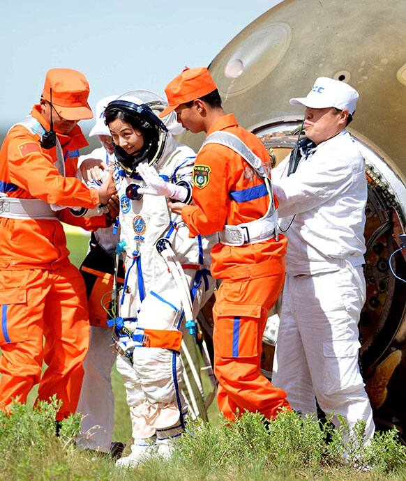 Chinese astronaut Wang Yaping, center, goes out of the re-entry capsule of China`s Shenzhou 10 spacecraft after its successful landing at the main landing site in Siziwang Banner, north China`s Inner Mongolia Autonomous Region.