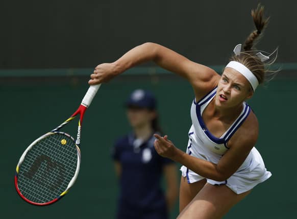 Anna Schmiedlova of Slovakia serves to Samantha Stosur of Australia during their Women`s first round singles match at the All England Lawn Tennis Championships in Wimbledon.