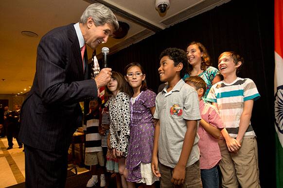 US Secretary of State John Kerry greets children during a meet and greet with staff and families from Embassy New Delhi.