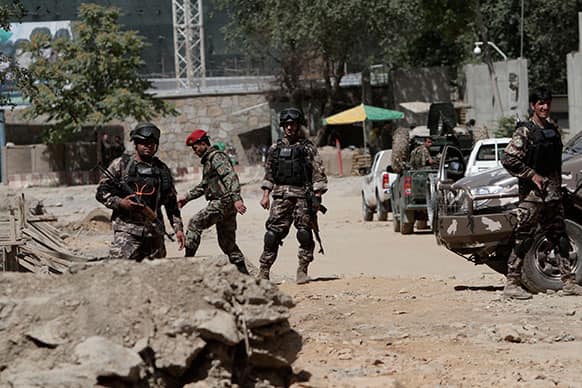 Afghan security force members investigate nearby the entrance gate of the presidential palace in Kabul, Afghanistan.