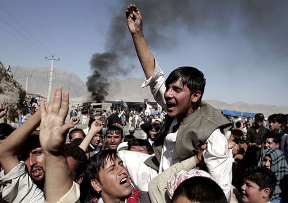 Afghans chant anti-government slogans after burning a truck, believed to be owned by foreigners during a demonstration in Kabul, Afghanistan.