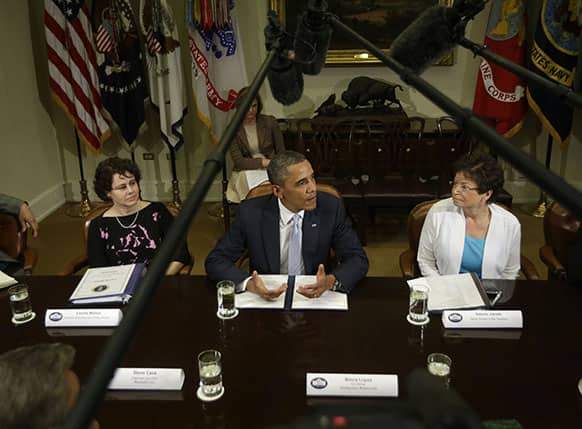 President Barack Obama, flanked by Cecilia Muñoz, director of the White House Domestic Policy Council, left, and senior White House adviser Valerie Jarrett, speaks in the Roosevelt Room of the White House in Washington.