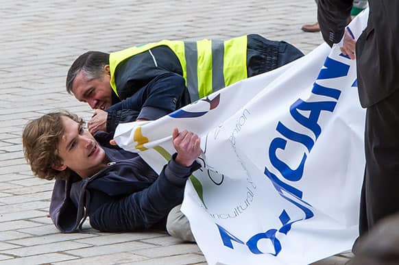 A demonstrator is arrested as he tries to deploy a banner at the start of a European foreign and agriculture ministers meeting in Luxembourg.