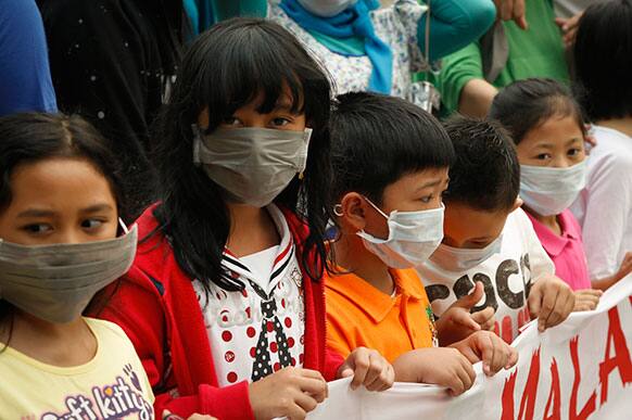 Tourists wear face mask as haze shrouds at a sightseeing spot near Petronas Twin Tower in Kuala Lumpur Malaysia.