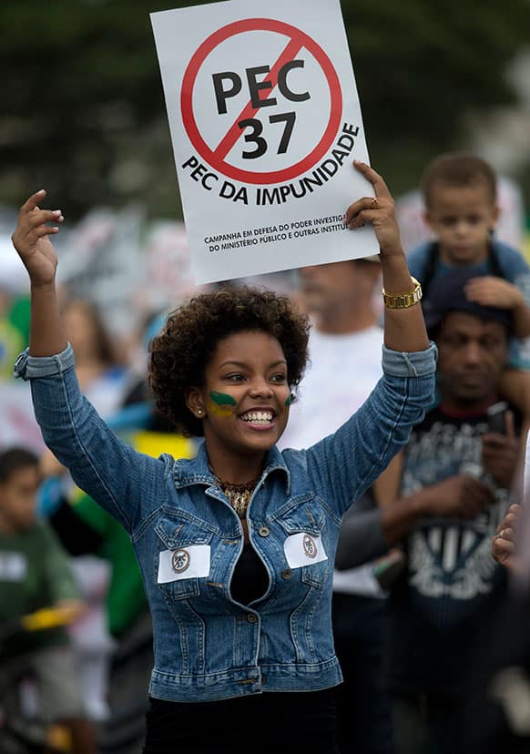 A woman holds a poster that reads