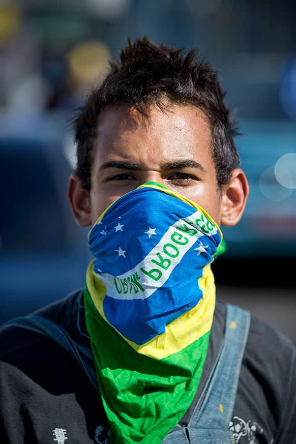 A protestor with a Brazilian flag covering his face stands on the main road leading to the Castelao stadium before the start of a soccer Confederations Cup group B match between Nigeria and Spain in Fortaleza, Brazil.