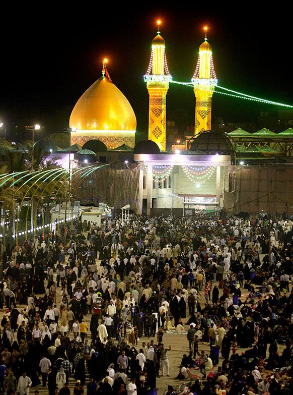 Shiite Muslim worshippers gather outside Imam Hussein shrine, seen in the background, during the preparations for the annual festival of Shabaniyah, which marks the anniversary of the birth of the ninth-century Shiite leader known as the Hidden Imam, in Karbala, Baghdad.