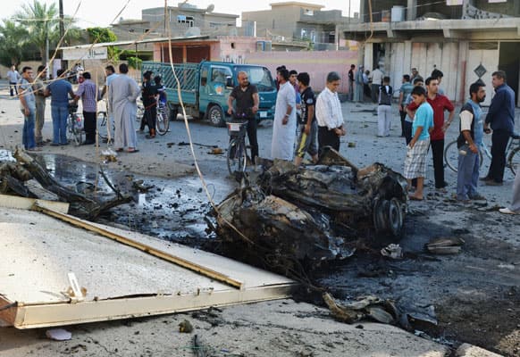 Civilians inspect the scene of two parked car bombs in the early morning at a residential area in Tuz Khormato, 130 miles (210 kilometers) north of Baghdad, Iraq.