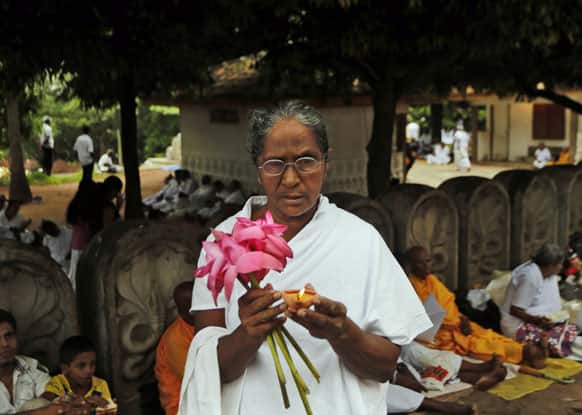 A Sri Lankan Buddhist devotee offers prayers during Poson full moon day religious observance at a temple in Kelaniya, on the outskirts of Colombo, Sri Lanka.