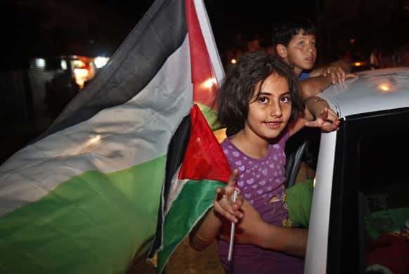 A Palestinian girl waves a national flag while celebrating after Palestinian singer Mohammed Assaf won a regional TV singing contest, along the streets of Gaza City.