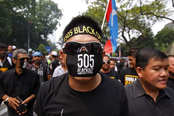 A protester wearing a black mask participates in the