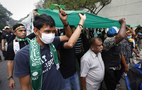 Protesters march with a flag of the Pan-Malaysian Islamic Party during the