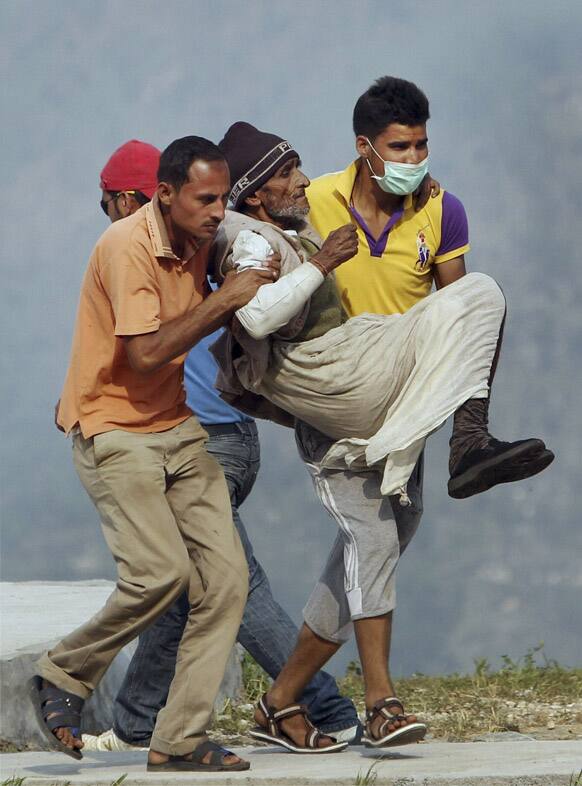 An elderly flood affected pilgrim is carried by National Disaster Response Force personnel at Guptakashi.