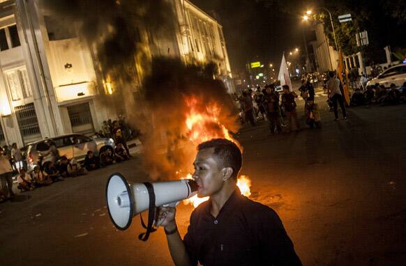 An Indonesian student shouts slogans as tires are burned during a protest against the fuel price hike that was just announced by the government in Yogyakarta, Indonesia.