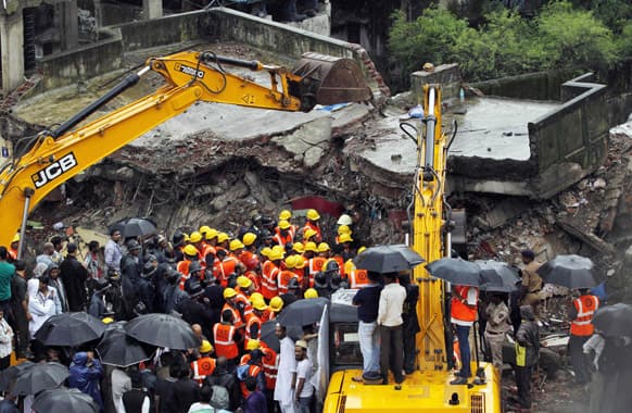 Rescue workers look for trapped people after a residential building collapsed in Thane district on the outskirts of Mumbai. A three-story building collapsed early Friday in India`s financial capital amid monsoon rains, killing at least 10 people, including five children, and injuring nine others, police said.