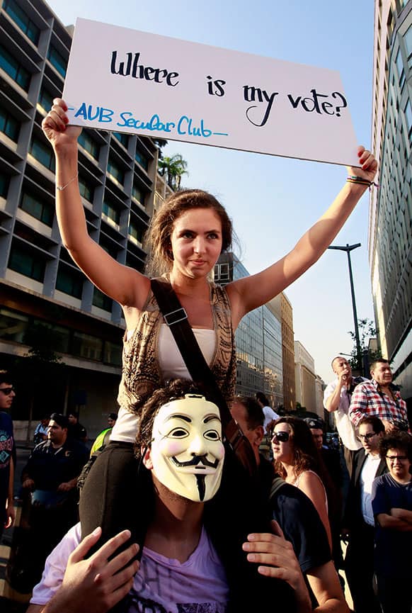 A protester holds a placard during a demonstration protesting the extension of the parliament’s mandate, in Beirut, Lebanon.