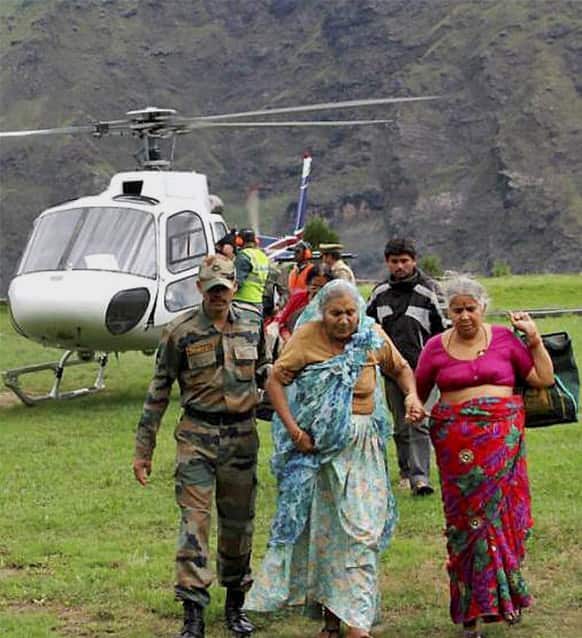 Army soldier helps flood affected elderly pilgrims after being evacuated from upper reaches of mountains, in Chamoli, in Indian northern state of Uttrakhand.