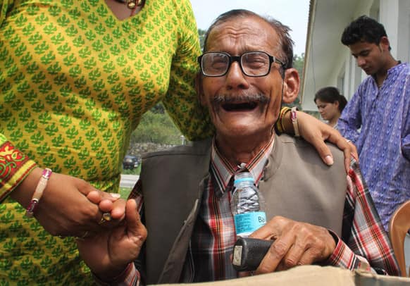 An elderly Indian stranded pilgrim is consoled by his relative as he is rescued from upper reaches of Uttrakhund, at Dehradun airport, in Dehradun.