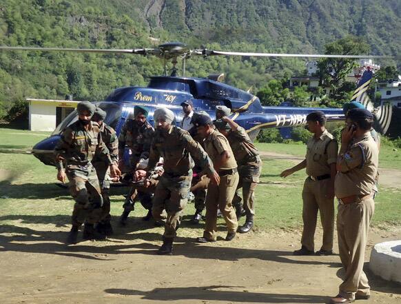 Army personnel carry an injured flood victim on a stretcher for treatment in Hemkund, in the northern Indian state of Uttarakhand.
