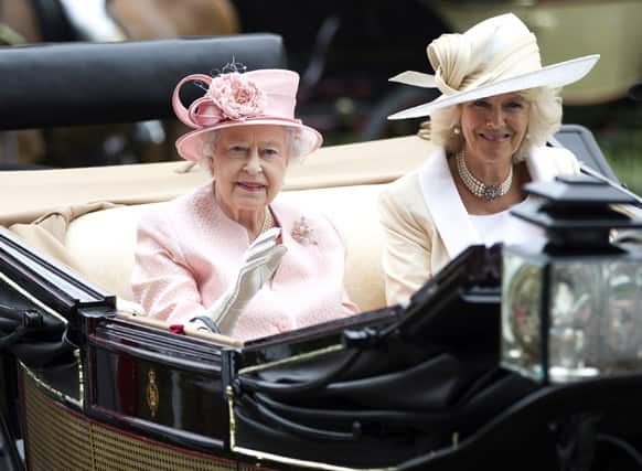 Britain`s Queen Elizabeth II waves to the crowds with Camilla, Duchess of Cornwall as they arrive by carriage on the first day of the Royal Ascot horse race meeting in Ascot.