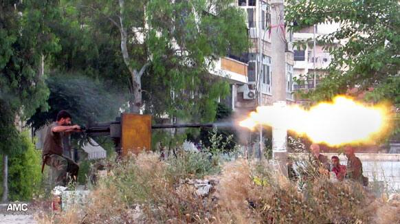 This citizen journalism image provided by Aleppo Media Center AMC which has been authenticated based on its contents and other AP reporting, shows a Syrian rebel firing a heavy machine gun towards Syrian soldiers loyal to Syrian president Bashar Assad, in Aleppo, Syria.
