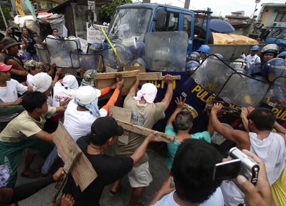 Striking workers of a steel factory clash with police and company guards to prevent the company from taking out their products Thursday June 20, 2013 at suburban Quezon city north of Manila, Philippines.