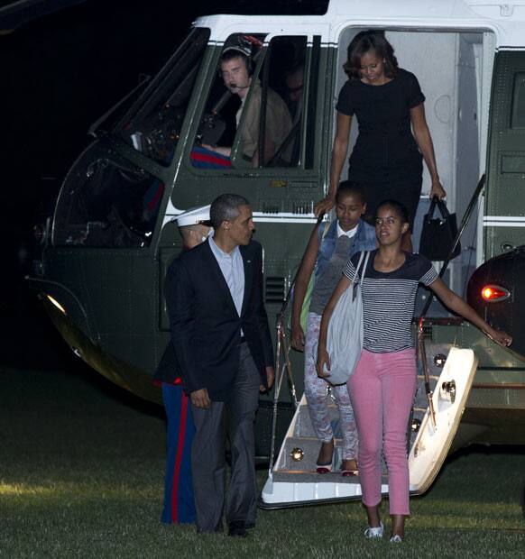 President Barack Obama, left, with first lady Michelle Obama, back, and their daughters Malia, front right, and Sasha, arrive at the White House in Washington.