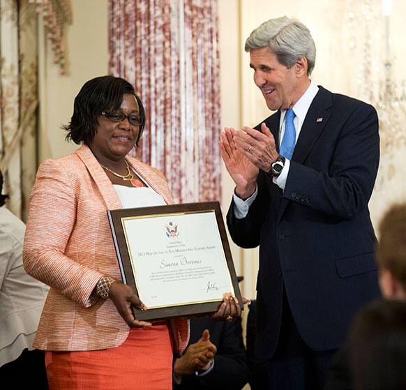 Secretary of State John Kerry, right, gives his applause after presenting Simona Broomes of Guyana, the 2013 TIP Report Heroes Award during the release the 2013 Trafficking in Persons (TIP) Report at the State Department in Washington.