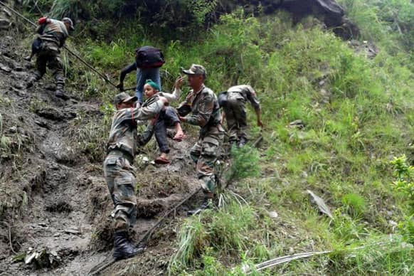 Soldiers help a child to climb down from a mountain, in Uttarkashi, in northern Indian state of Uttrakhand.