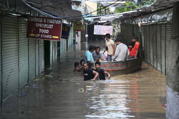 People use a boat to cross a Tibetan market along the banks of the Yamuna River, in New Delhi.