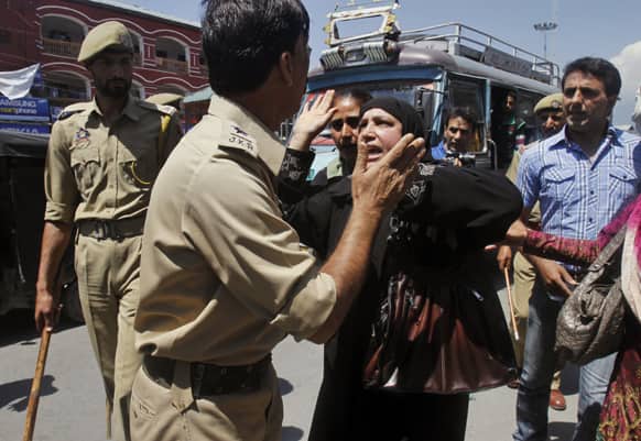 A Kashmiri government employee woman argues with a police officer during a protest in Srinagar.