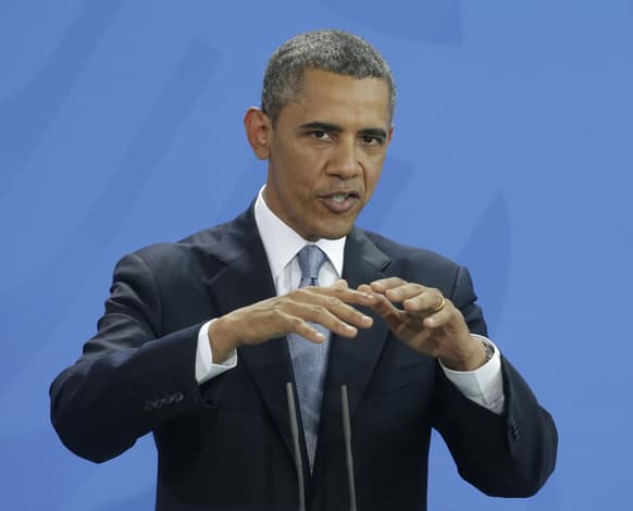 US President Barack Obama gestures during their joint news conference with German Chancellor Angela Merkel at the Chancellery in Berlin, Germany.