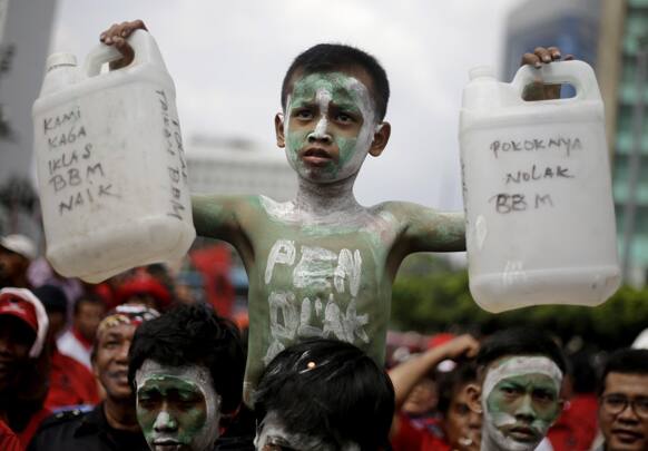 An Indonesian youth with painted face and body holds plastic jerrycans during a protest against the government`s plan to raise fuel prices in Jakarta, Indonesia.