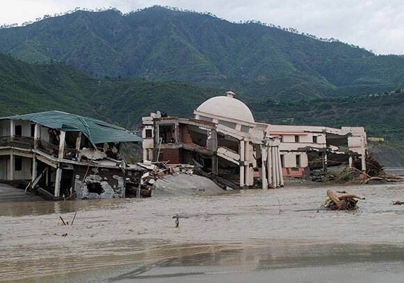A damaged government guest house falls into the flooded water of the River Ganges in Shrinagar district, in the northers Indian state of Uttarakhand.