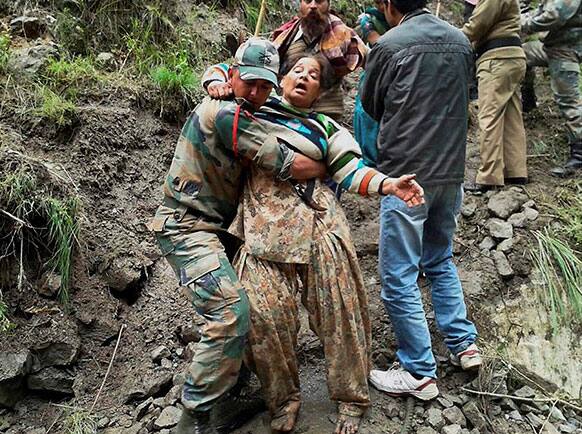 An Indian army personnel carries a stranded woman pilgrim to a safer area in Chamoli district, in the northern Indian state of Uttarakhand.