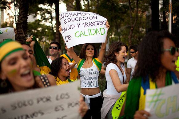 Dianine Nunes holds a banner that reads in Spanish;