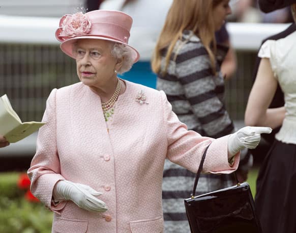 Britain`s Queen Elizabeth II gestures as she watches the horses for the first race in the parade ring, on the first day of the Royal Ascot horse race meeting in Ascot, England.