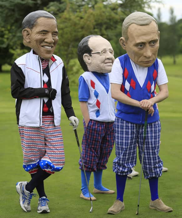 Members of the NGO group Oxfam, dressed in golf clothes and wearing paper mache masks, imitate G-8 leaders during a demonstration at the Enniskillen Golf course near the venue of the G-8 summit in Enniskillen, Northern Ireland.