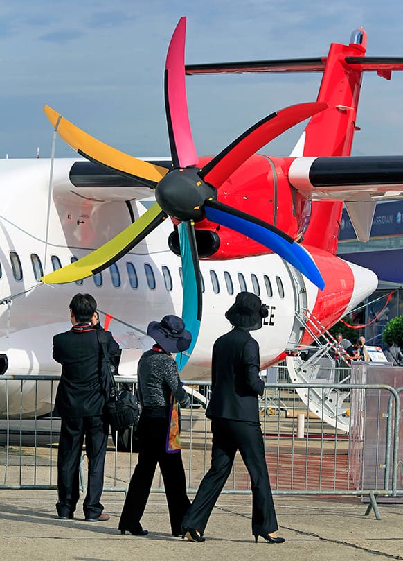 Visitors watch the multicolor propeller of an ATR 72-600 jet of Colombian company Avianca, at the 50th Paris Air Show at Le Bourget airport, north of Paris.