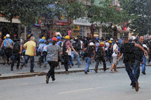 Riot police use water cannons to chase people during a rally by the labor unions in Istanbul, Turkey.
