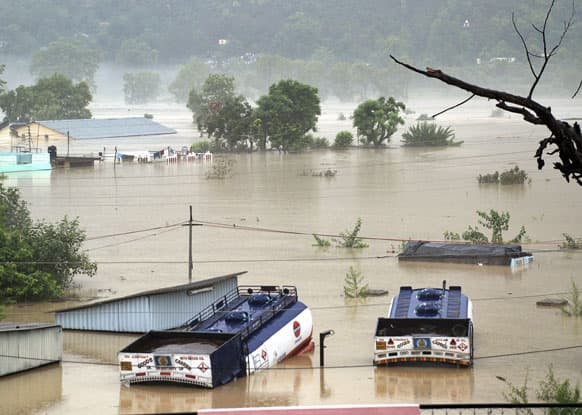 Houses are submerged as trucks flow in flood waters of the Bhagirathi River in Shrinagar district in northern Indian state of Uttarakhand.