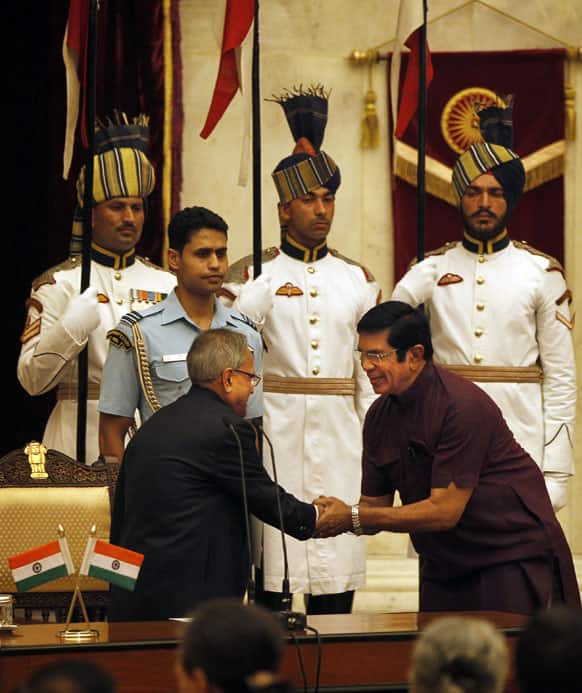 Pranab Mukherjee, left, greets Oscar Fernandes, right, after administrating him the oath of union cabinet minister at a function at the presidential palace, in New Delhi.